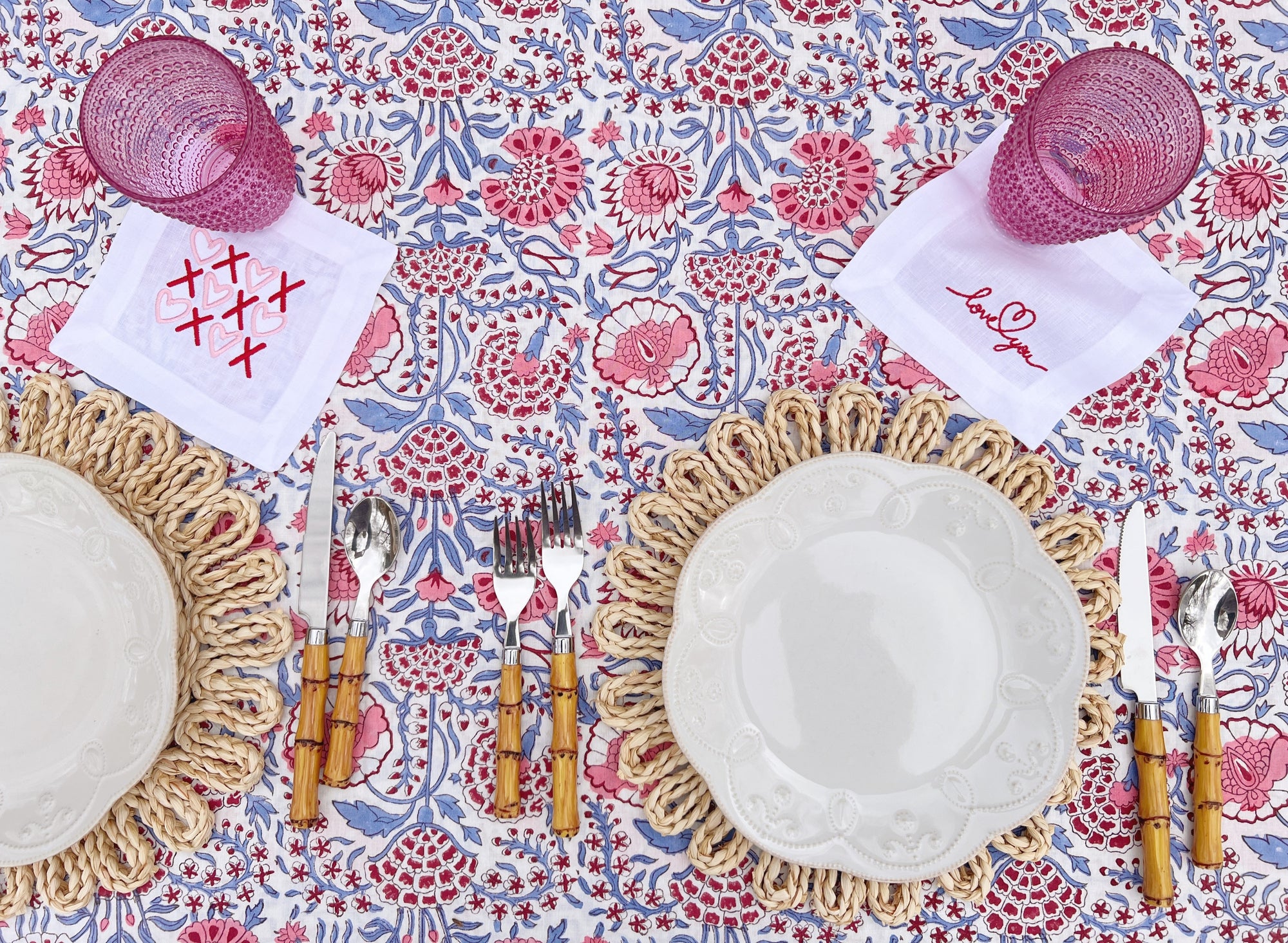 Pink, red, and blue Valentine's Day brunch table inspiration with embroidered cocktail napkins and pink glassware